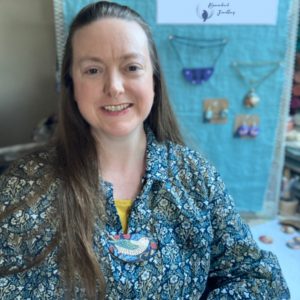 Amanda, Founder of Bowerbird Jewellery at her studio desk, wearing a William Morris statement necklace of her own creation
